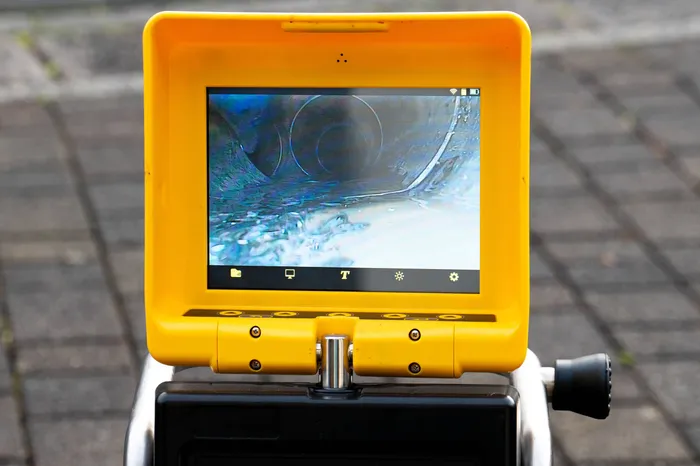 plumber reviewing footage from a professional pipe video inspection