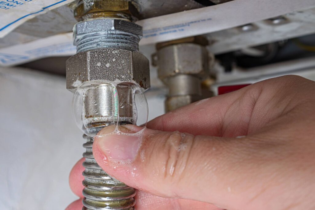 bubbles forming after placing a soapy water mixture on a gas line indicating a leak